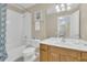 Clean bathroom featuring a shower-tub combo, toilet, and sink with a wood cabinet at 2621 Archfeld Blvd, Kissimmee, FL 34747