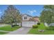 Charming two-story home featuring a tile roof, manicured lawn, and a two-car garage at 2621 Archfeld Blvd, Kissimmee, FL 34747