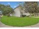 Beautiful side view of home with a well-manicured lawn and mature trees on a corner lot at 2621 Archfeld Blvd, Kissimmee, FL 34747