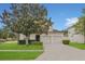 Charming two-story home with a two-car garage, lush landscaping, and a well-maintained lawn at 2621 Archfeld Blvd, Kissimmee, FL 34747