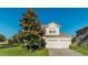 Two-story home features a spacious two car garage and a manicured front lawn with mature tree at 2621 Archfeld Blvd, Kissimmee, FL 34747