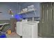 Well-equipped laundry room with a washer, dryer, shelving, and essential laundry supplies at 2621 Archfeld Blvd, Kissimmee, FL 34747