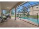 Spacious screened patio with an outdoor dining set, chairs, and view of the backyard pool at 2621 Archfeld Blvd, Kissimmee, FL 34747