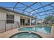 Beautiful private pool with a screened enclosure, hot tub, and lounge area, perfect for relaxation at 2621 Archfeld Blvd, Kissimmee, FL 34747