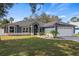 Charming single-story home with blue siding, a well-manicured lawn, and an attached two-car garage at 2810 Abbey Ave, Orlando, FL 32833