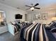 Comfortable bedroom with stylish striped bedding, a flat-screen TV, and tasteful wall decor at 2943 Banana Palm Dr, Kissimmee, FL 34747