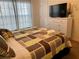 Bedroom featuring a window, carpet, white dresser and patterned bedding at 2943 Banana Palm Dr, Kissimmee, FL 34747