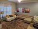 Bright living room with neutral tones, a large window, stylish furnishings, and contemporary art at 2943 Banana Palm Dr, Kissimmee, FL 34747