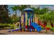 Colorful community playground with multiple slides and climbing features surrounded by lush tropical landscaping at 2943 Banana Palm Dr, Kissimmee, FL 34747