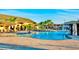 Stunning community pool with water features and plenty of lounge chairs under blue umbrellas at 2943 Banana Palm Dr, Kissimmee, FL 34747