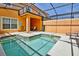 Relaxing screened-in pool area with hot tub, lounge chair, and covered patio with seating at 2943 Banana Palm Dr, Kissimmee, FL 34747