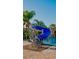 Community pool with a blue spiral waterslide and lush tropical landscaping, creating a resort-style atmosphere at 2943 Banana Palm Dr, Kissimmee, FL 34747