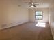 Cozy bedroom with large window, ceiling fan, and neutral carpeting at 3188 Owassa Ct, Kissimmee, FL 34746