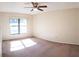Sunny bedroom with large window, ceiling fan, and carpeted floor at 3188 Owassa Ct, Kissimmee, FL 34746