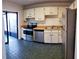 The kitchen features stainless steel appliances, tiled floor, and white cabinets at 3188 Owassa Ct, Kissimmee, FL 34746