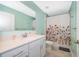 Bathroom with a white vanity, quartz countertop, and a floral shower curtain over a tub at 4418 Blackbird St, Kissimmee, FL 34746