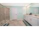 Bathroom showcasing double sinks, shower with glass door, and tiled floor with accent rug at 4418 Blackbird St, Kissimmee, FL 34746