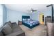 Light blue bedroom with cozy queen bed, ceiling fan, gray sofa, and dark gray nightstands at 4418 Blackbird St, Kissimmee, FL 34746