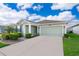 Charming single-story home with green siding, well-manicured landscaping, and a two-car garage at 4418 Blackbird St, Kissimmee, FL 34746
