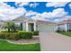 Charming single-story home with green siding, well-manicured landscaping, and a two-car garage at 4418 Blackbird St, Kissimmee, FL 34746