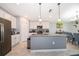 An open kitchen features white cabinets, stainless appliances, a gray island, and a view to the dining area at 4418 Blackbird St, Kissimmee, FL 34746