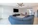 Spacious living room with a plush blue sectional, large TV, and neutral walls with plenty of light at 4418 Blackbird St, Kissimmee, FL 34746