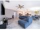 Bright living room with a ceiling fan, blue sofa, and open view to the kitchen and dining area at 4418 Blackbird St, Kissimmee, FL 34746