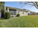 Expansive backyard featuring a well-manicured lawn, mature landscaping, and a partial view of neighboring homes at 4976 Creekside Park Ave, Orlando, FL 32811