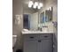 Bathroom features a vanity and sink with a large mirror and light fixture at 569 La Mirage St, Davenport, FL 33897
