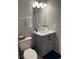 Compact bathroom featuring a vanity with cabinets, a mirrored cabinet, and a toilet with a patterned rug at 569 La Mirage St, Davenport, FL 33897