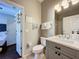 Well-lit bathroom with a stylish gray vanity, modern fixtures, and convenient access to the adjacent bedroom at 569 La Mirage St, Davenport, FL 33897