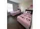 Charming bedroom with two twin beds, pink bedding, and fun decor for children at 569 La Mirage St, Davenport, FL 33897
