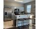 Bright kitchen with stainless steel refrigerator, breakfast bar and gray cabinets at 569 La Mirage St, Davenport, FL 33897