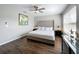This main bedroom offers wood floors, ceiling fan, and a large decorative headboard at 569 La Mirage St, Davenport, FL 33897