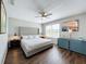 This main bedroom offers wood floors, ceiling fan, and a large decorative headboard at 569 La Mirage St, Davenport, FL 33897