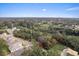 An aerial view of the land showcasing lush trees and a view of neighborhood homes at 572 Sanctuary Golf Pl, Apopka, FL 32712