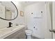 Modern bathroom with a stylish vanity, round mirror, and a shower with fresh white tiles at 6165 Carrier Dr # 2306, Orlando, FL 32819