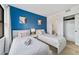 Inviting bedroom featuring twin beds, modern decor, blue accent wall, and a closet at 6165 Carrier Dr # 2306, Orlando, FL 32819