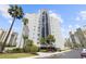 Modern high-rise building with elegant landscaping and tall palm trees, providing a luxurious and inviting curb appeal at 6165 Carrier Dr # 2306, Orlando, FL 32819