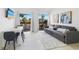 Bright living room featuring a comfortable sofa, dining area, and sliding glass doors to a balcony with palm tree views at 6165 Carrier Dr # 2306, Orlando, FL 32819