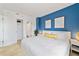 Bright bedroom with a vibrant blue accent wall, modern decor, and closet at 6165 Carrier Dr # 2306, Orlando, FL 32819