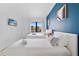 Bright bedroom features a blue accent wall, two twin beds, and a mounted TV at 6165 Carrier Dr # 2306, Orlando, FL 32819