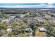 An aerial view of the home and surrounding neighborhood featuring lush trees and a nearby pond at 6408 Ridge Ter, Orlando, FL 32810