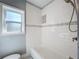 Bathroom with a window, bathtub, and white subway tile surround at 6408 Ridge Ter, Orlando, FL 32810