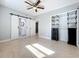 Neutral bedroom features tile floors, ceiling fan, adjacent bathroom with sliding door, and custom closet system at 6408 Ridge Ter, Orlando, FL 32810