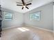 Empty bedroom shows tile flooring, neutral paint, ceiling fan, and natural light from two windows at 6408 Ridge Ter, Orlando, FL 32810