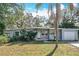 Charming single-story home with lush landscaping, including mature trees, and a well-maintained lawn at 6408 Ridge Ter, Orlando, FL 32810