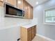 Kitchen area featuring stainless steel microwave, wood cabinets, white subway tile backsplash, and marble countertop at 6408 Ridge Ter, Orlando, FL 32810