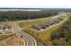 Community aerial view featuring new homes, lush green spaces, and scenic roadways with lake views in a tranquil setting at 6895 Botanic Blvd, Harmony, FL 34773