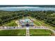 Aerial view of community clubhouse and pool area, surrounded by lush landscaping and a lake backdrop at 6895 Botanic Blvd, Harmony, FL 34773